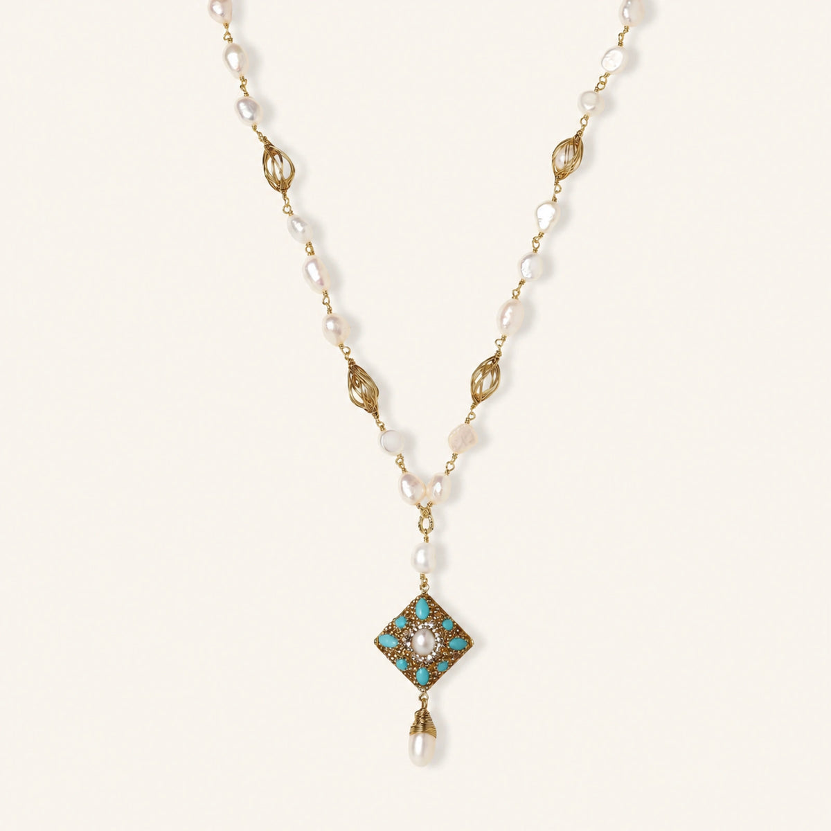 Y-shaped necklace with freshwater pearls, gold filigree stations, and ornate diamond-shaped centerpiece with pearl drop