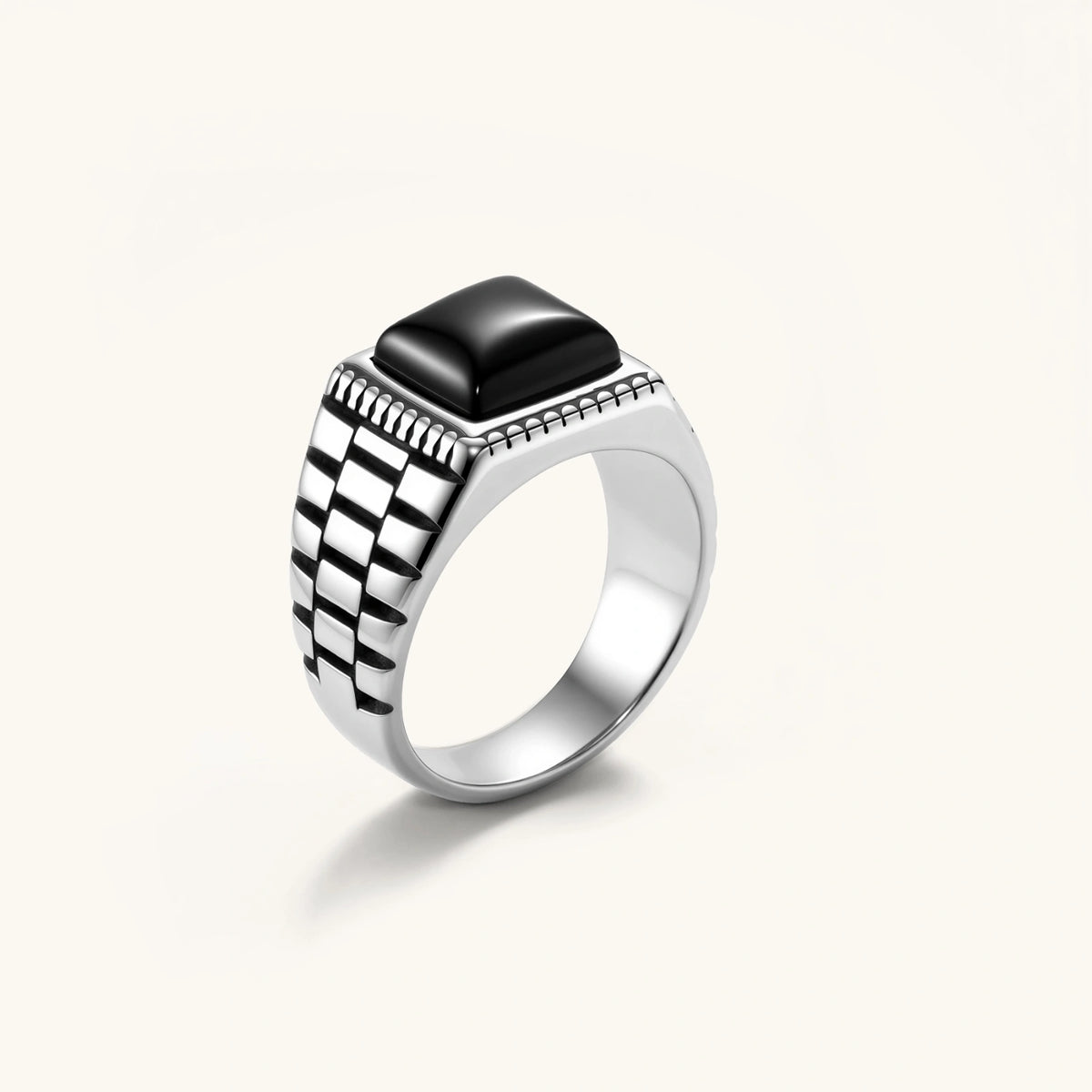 Silver stainless steel signet ring with checkered band texture, beaded border, and square black onyx cabochon stone center.